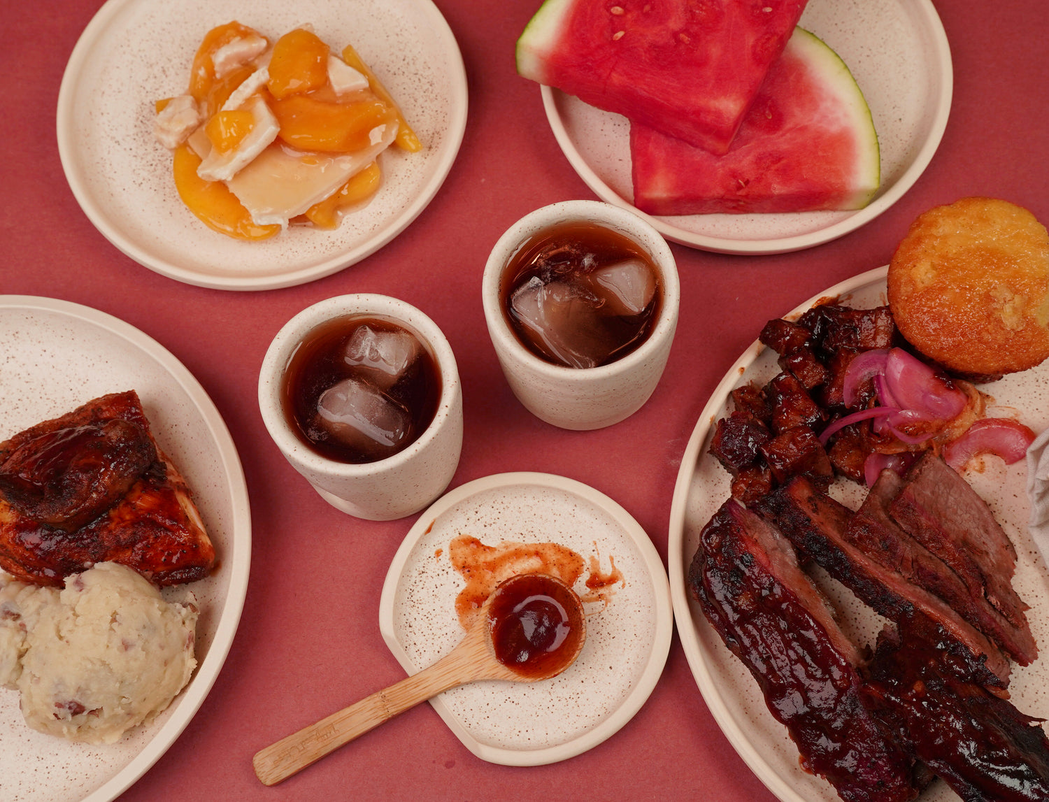 a family-sized meal of barbecue served on handmade ceramic dinnerware